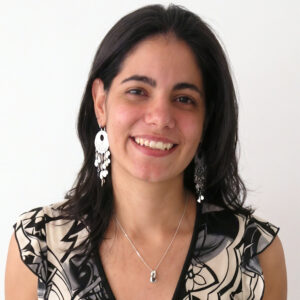 Professional headshot of an AEC marketing expert smiling warmly, wearing a black and white patterned top, white background.